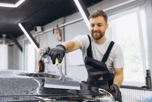 Auto detailer working under bright LED shop lights